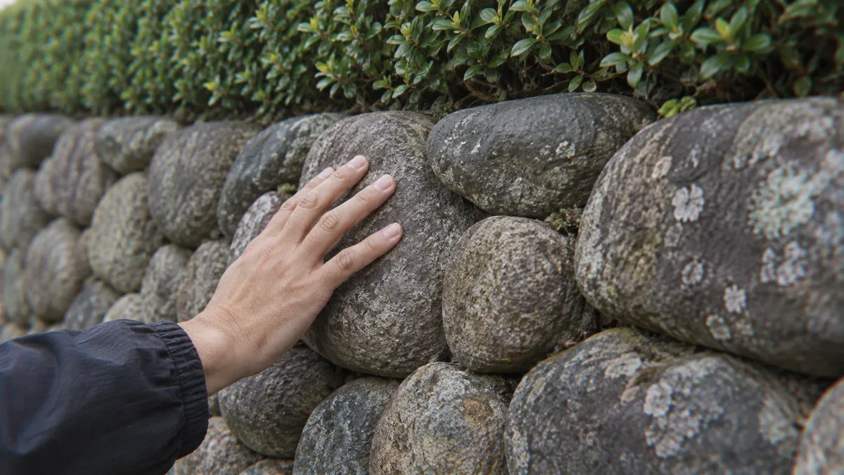 丸い川石を積んだ石垣を近くから見る
