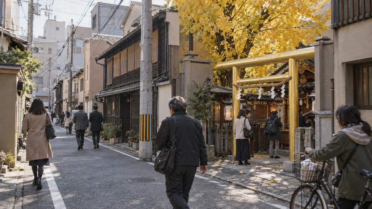 町家の壁と低い建物にはさまれた細い通りに、社が歩道からじかに開いている